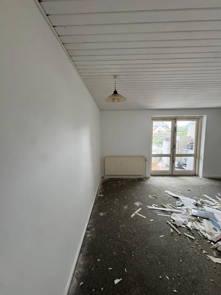 Rum med byggeaffald foran altandør