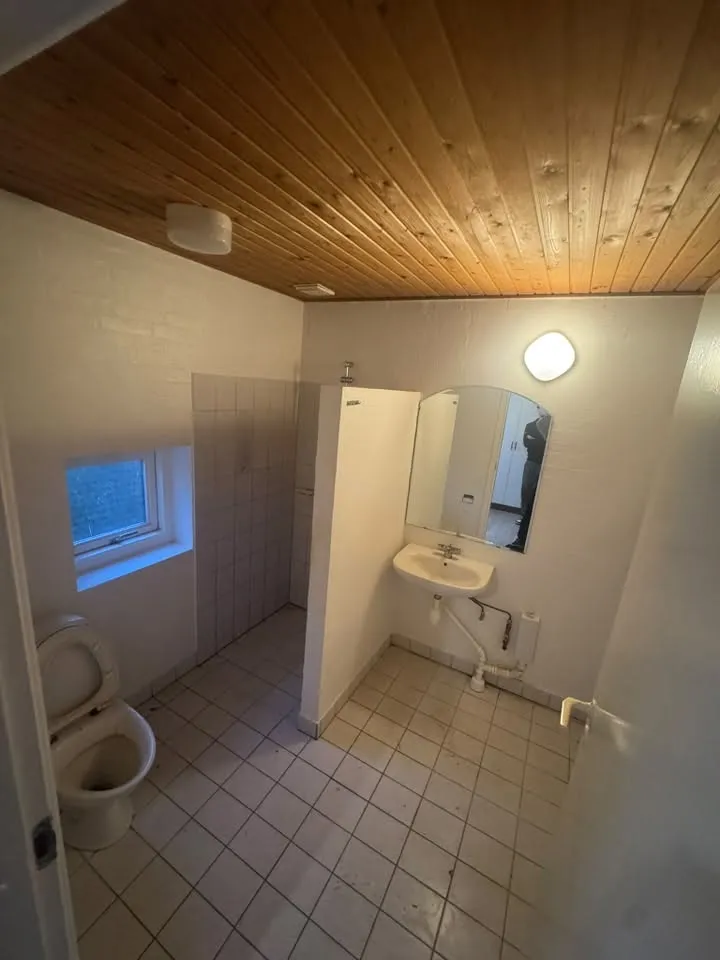 Badeværelse med klinker og træloft