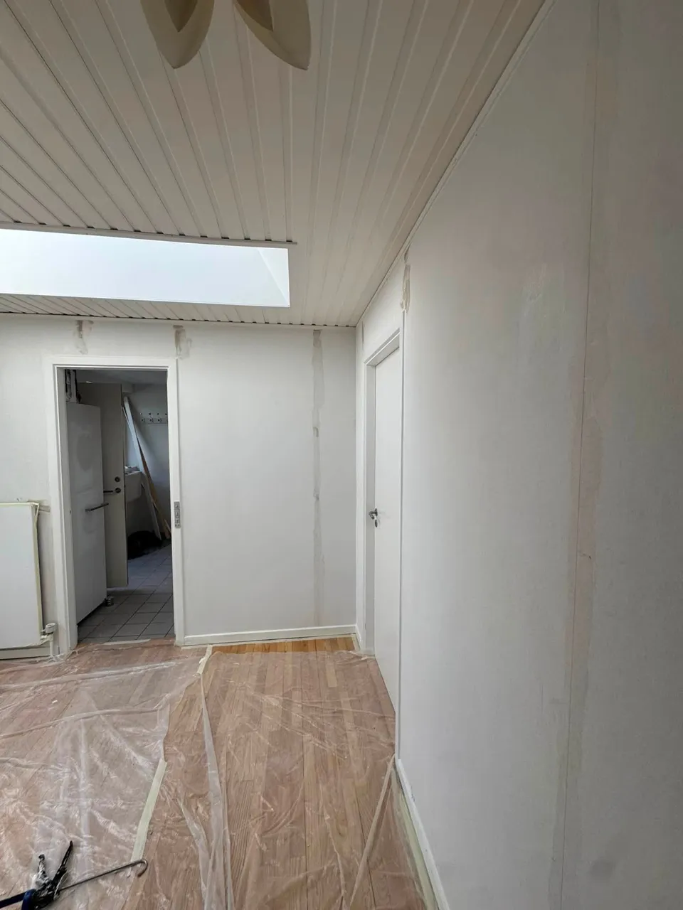 Gang med ovenlys og afdækket gulv